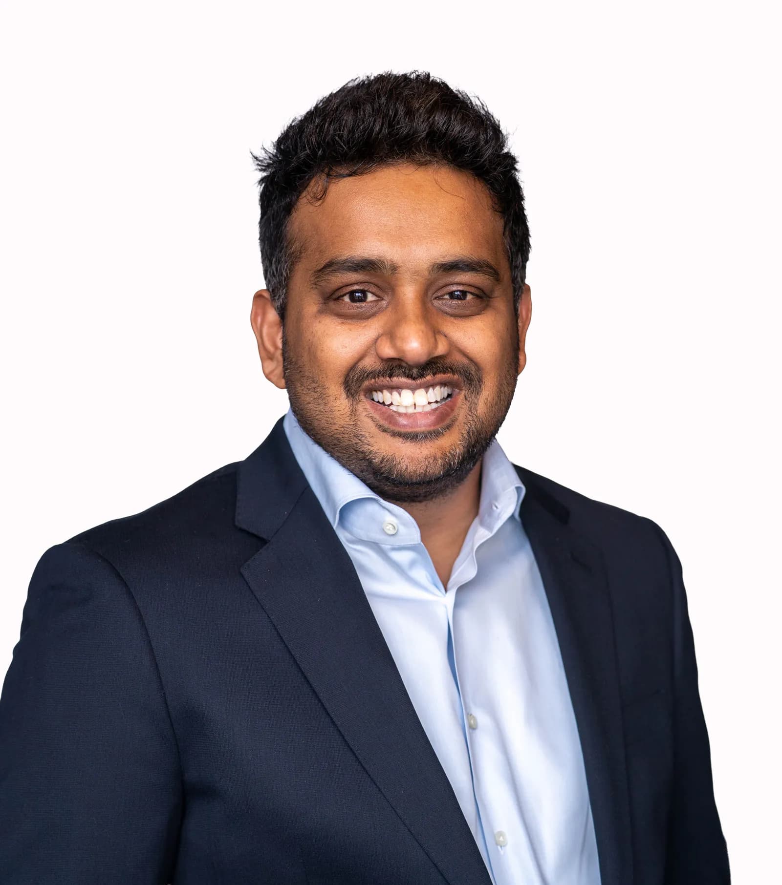 Portrait of Aditya Kasturi smiling in studio lighting.